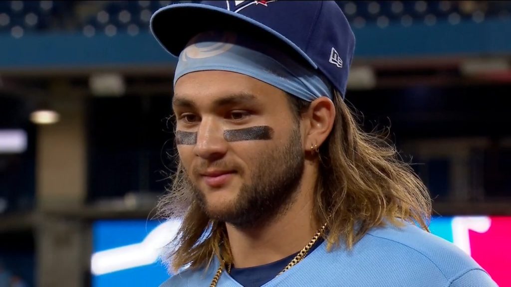 Bo Bichette of the Toronto Blue Jays flicks his hair back after