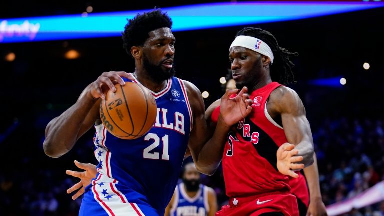 Philadelphia 76ers' Joel Embiid, left, tries to get past Toronto Raptors' Precious Achiuwa during the second half of an NBA basketball game, Sunday, March 20, 2022, in Philadelphia. (Matt Slocum/AP Photo)