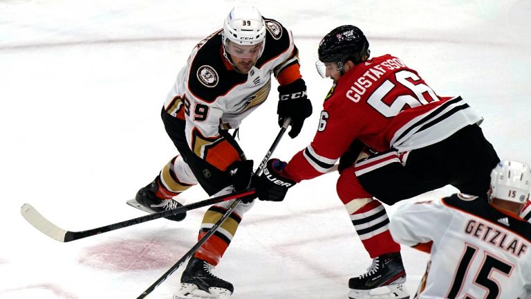 Anaheim Ducks centre Sam Carrick, left, shoots against Chicago Blackhawks defenceman Erik Gustafsson during the first period of an NHL hockey game in Chicago, Saturday, Jan. 15, 2022. The Blackhawks won 3-0.(Nam Y. Huh/AP)