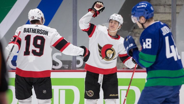 Ottawa Senators' Tim Stuetzle, centre, of Germany, and Drake Batherson, left, celebrate Stuetzle's goal as Vancouver Canucks' Olli Juolevi, of Finland, skates to the bench during the first period of an NHL hockey game in Vancouver, on Thursday, April 22, 2021. THE CANADIAN PRESS/Darryl Dyck