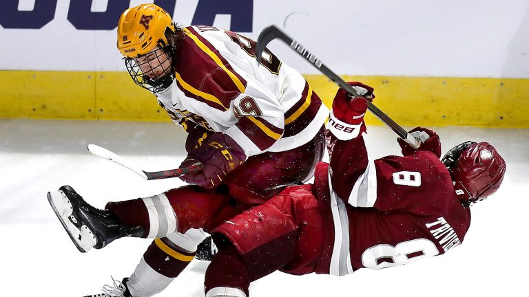 Massachusetts forward Bobby Trivigno (8) is checked by Minnesota's Matthew Knies, top, in the second period of an NCAA college hockey game in Worcester, Mass., Friday, March 25, 2022. (John Tlumacki/The Boston Globe via AP)