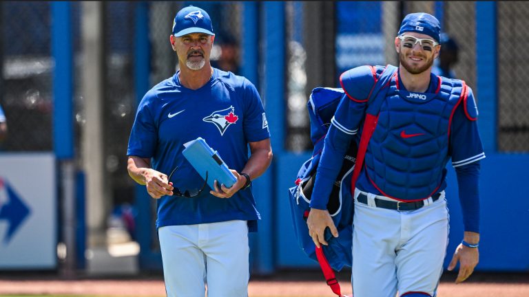 Toronto Blue Jays pitching coach Pete Walker, left, and catcher Danny Jansen walk to the dugout before the start of a spring training baseball game at TD Ballpark, in Dunedin, Fla., Sunday, March 27, 2022. (Steve Nesius/CP)