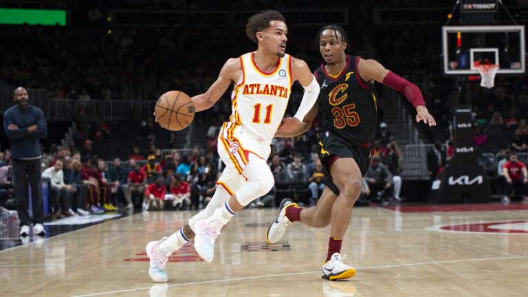 Atlanta Hawks guard Trae Young (11) dribbles past Cleveland Cavaliers forward Isaac Okoro (35) during the first half of an NBA basketball game. (Hakim Wright Sr./AP)