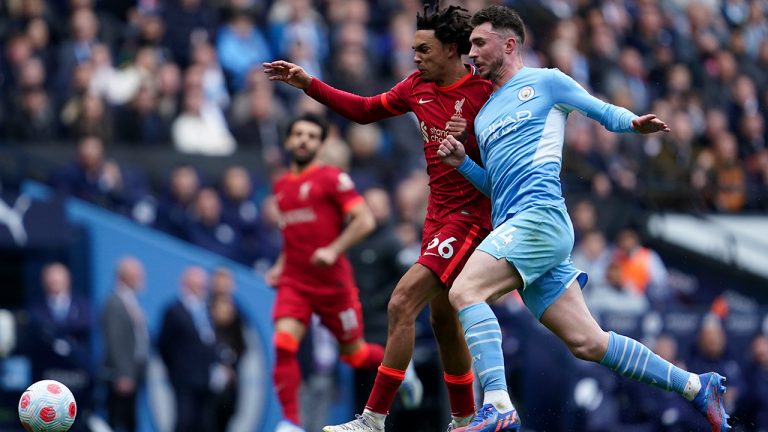 Liverpool's Trent Alexander-Arnold, left, duels for the ball with Manchester City's Aymeric Laporte during the English Premier League soccer match between Manchester City and Liverpool, at the Etihad stadium in Manchester, England, Sunday, April 10, 2022. (Jon Super/AP)