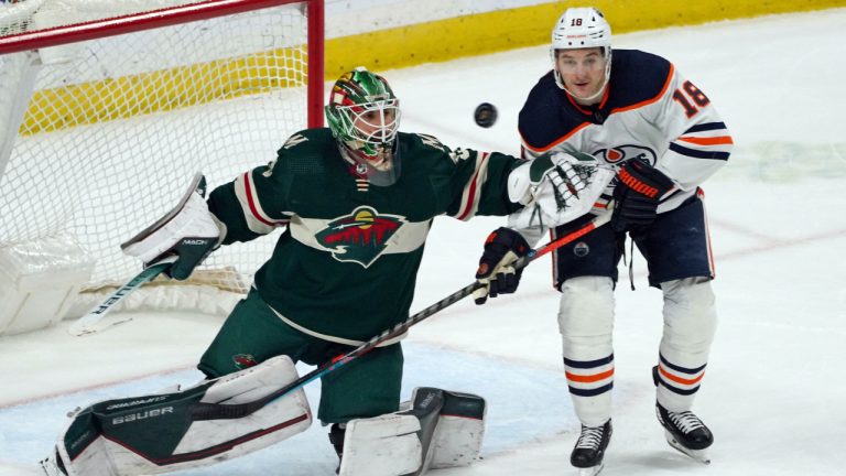 Minnesota Wild goalie Cam Talbot, left, deflects a shot next to Edmonton Oilers' Zach Hyman during the second period of an NHL hockey game Tuesday, April 12, 2022, in St. Paul, Minn. (AP Photo/Jim Mone)