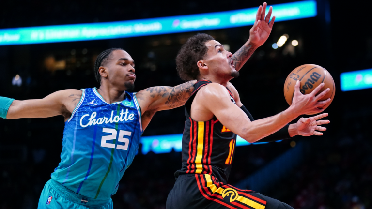 Atlanta Hawks guard Trae Young (11) drives to the basket past Charlotte Hornets forward P.J. Washington (25) during the first half of an NBA play-in basketball game Wednesday, April 13, 2022, in Atlanta. (AP)