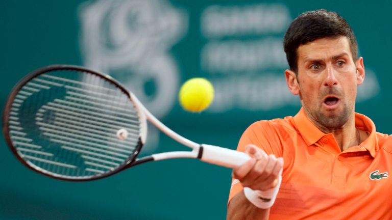 Novak Djokovic of Serbia returns a ball to Laslo Djere of Serbia during their tennis match of the Serbia Open tennis tournament in Belgrade, Serbia, Wednesday, April 20, 2022. (AP)