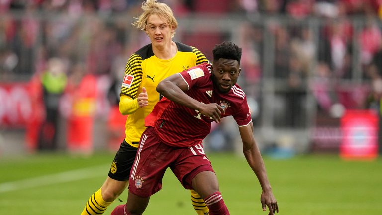 Bayern's Alphonso Davies, front, duels for the ball with Dortmund's Julian Brandt during the German Bundesliga soccer match between Bayern Munich and Borussia Dortmund, at the Allianz Arena, in Munich, Germany, Saturday, April 23, 2022. (Matthias Schrader/AP)