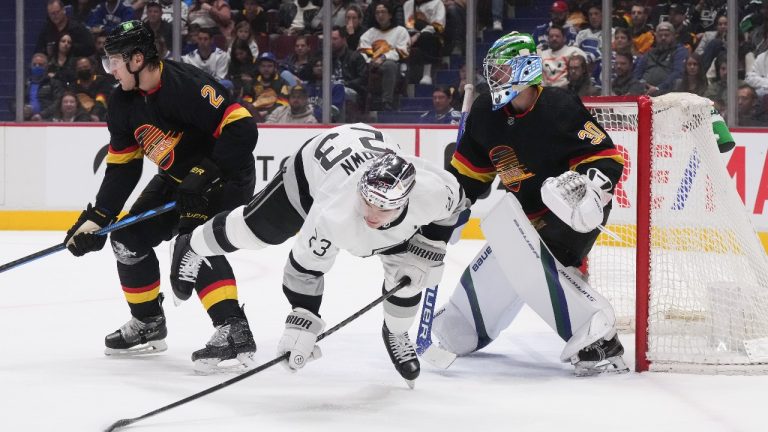 Los Angeles Kings right wing Dustin Brown (23) is upended in front of Vancouver Canucks goalie Spencer Martin (30) as Canucks Luke Schenn (2) defends during first period NHL action in Vancouver on Thursday, April 28, 2022. (Darryl Dyck/THE CANADIAN PRESS)