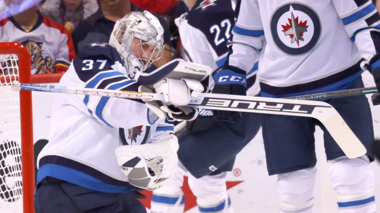 Winnipeg Jets goaltender Connor Hellebuyck (37) makes a glove-save during the first period of an NHL hockey game against the Florida Panthers, Friday, April 15, 2022, in Sunrise, Fla. (Reinhold Matay/AP)