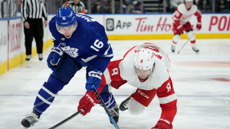 Toronto Maple Leafs right wing Mitchell Marner (16) and Detroit Red Wings defenceman Jake Walman (8) move towards the puck during second period NHL hockey action in Toronto, Tuesday, April 26, 2022. (Frank Gunn/CP)