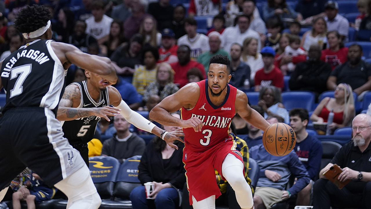 New Orleans Pelicans guard CJ McCollum (3) drives to the basket against San Antonio Spurs guard Dejounte Murray (5) and guard Josh Richardson (7) in the second half of an NBA basketball game. (Gerald Herbert/AP)