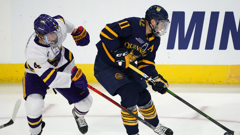 Quinnipiac forward Wyatt Bongiovanni, right, looks to pass the puck as Minnesota St. defenseman Andy Carroll covers in the first period of an NCAA West Regional college hockey semifinal game. (David Zalubowski/AP)