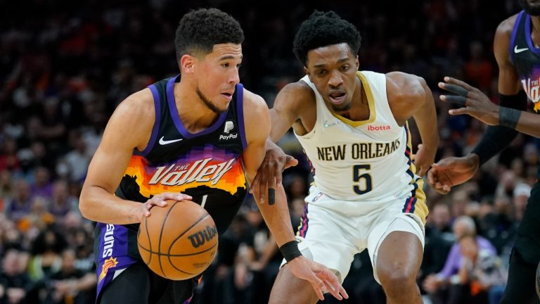 Phoenix Suns guard Devin Booker (1) drives as New Orleans Pelicans forward Herbert Jones (5) defends during the first half of Game 2 of an NBA basketball first-round playoff series, Tuesday, April 19, 2022, in Phoenix. (Matt York/AP)