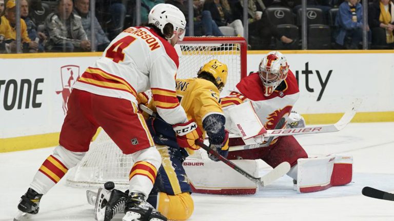 Calgary Flames' Rasmus Andersson (4) and goaltender Dan Vladar (80) defend against Nashville Predators' Nick Cousins (21) in the second period of an NHL hockey game. (Mark Humphrey/AP)