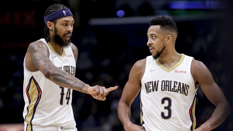 New Orleans Pelicans forward Brandon Ingram (14) and guard CJ McCollum (3) talk during a timeout in the second half of an NBA basketball game. (Derick Hingle/AP)