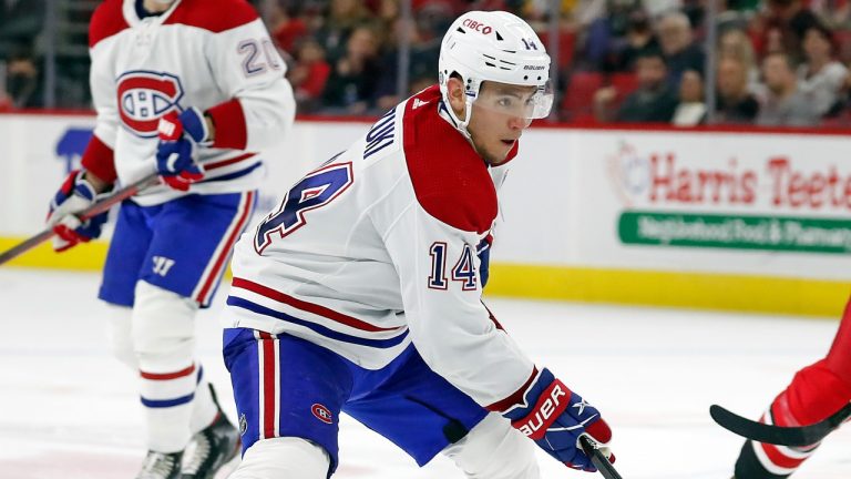 Montreal Canadiens' Nick Suzuki (14) skates with the puck in front of Carolina Hurricanes' Derek Stepan (18) during the third period of an NHL hockey game in Raleigh, N.C., Thursday, March 31, 2022. (Karl B DeBlaker/AP)