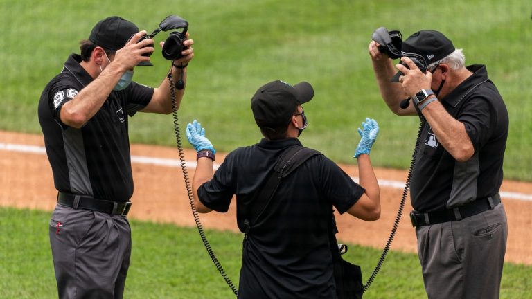 Umpires remove their headphones after reviewing a play during the eighth inning of a baseball game between the Washington Nationals and the Atlanta Braves in Washington, Sunday, Sept. 13, 2020. (Manuel Balce Ceneta/AP Photo)