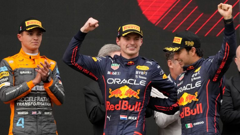 Red Bull driver Max Verstappen, center, of the Netherlands, winner of the Emilia Romagna Formula One Grand Prix, celebrates on the podium with second placed Red Bull driver Sergio Perez, left, of Mexico, as third placed McLaren driver Lando Norris of Britain looks them, at the Enzo and Dino Ferrari racetrack, in Imola, Italy, Sunday, April 24, 2022. (Luca Bruno/AP)