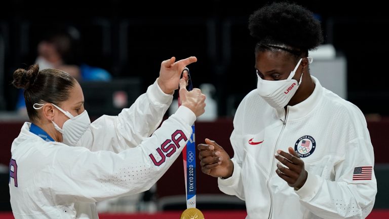 United States's Diana Taurasi, left, puts a medal on teammate Sylvia Fowles during the medal ceremony for women's basketball at the 2020 Summer Olympics, Sunday, Aug. 8, 2021, in Saitama, Japan. (AP Photo/Charlie Neibergall)