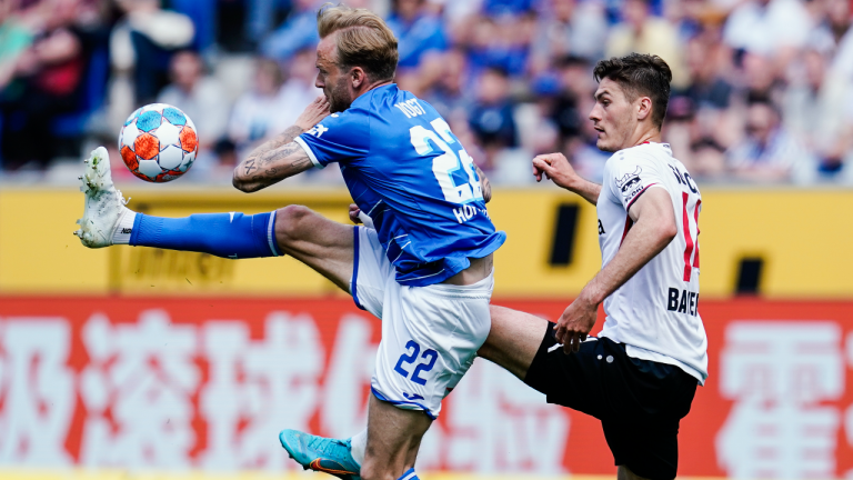 Hoffenheim's Kevin Vogt, left, and Leverkusen's Patrik Schick fight for the ball during a German Bundesliga soccer match between TSG 1899 Hoffenheim and 1.FC Cologne in Sinsheim, Germany, Saturday, May 7, 2022. (AP)