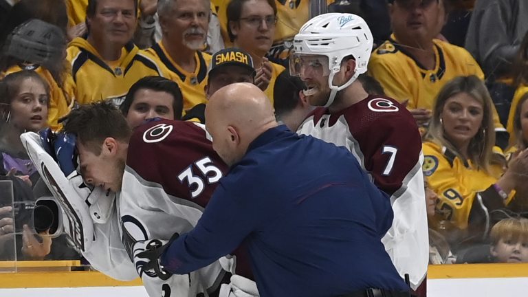 Colorado goaltender Darcy Kuemper is helped off the ice after a stick penetrated his mask during the first period in Game 3 of a first-round playoff series against the Nashville Predators on Saturday in Nashville, Tenn. (Mark Zaleski/AP Photo)