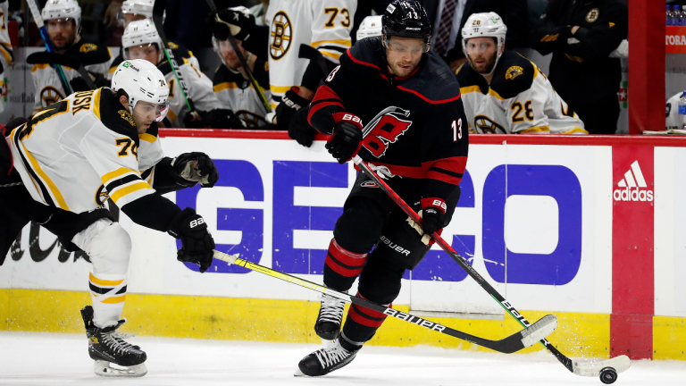 Carolina Hurricanes' Max Domi (13) battles for the puck with Boston Bruins' Jake DeBrusk (74) during the second period of Game 7 of an NHL hockey Stanley Cup first-round playoff series in Raleigh, N.C., Saturday, May 14, 2022. (AP)