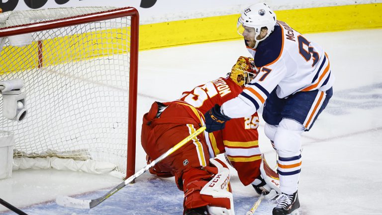 Edmonton Oilers centre Connor McDavid, right, scores on Calgary Flames goalie Jacob Markstrom during second period NHL second round playoff hockey action. (Jeff McIntosh/CP)