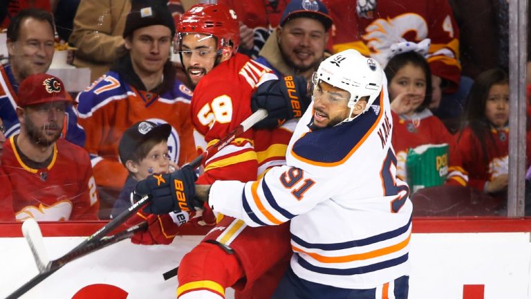 Edmonton Oilers' Evander Kane, right, hits Calgary Flames' Oliver Kylington, from Sweden. (CP/file)