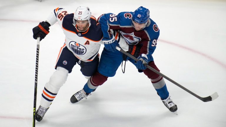 Edmonton Oilers defenseman Darnell Nurse, left, tangles with Colorado Avalanche left wing Andre Burakovsky in the first period of an NHL hockey game Monday, March 21, 2022, in Denver. (David Zalubowski/AP)