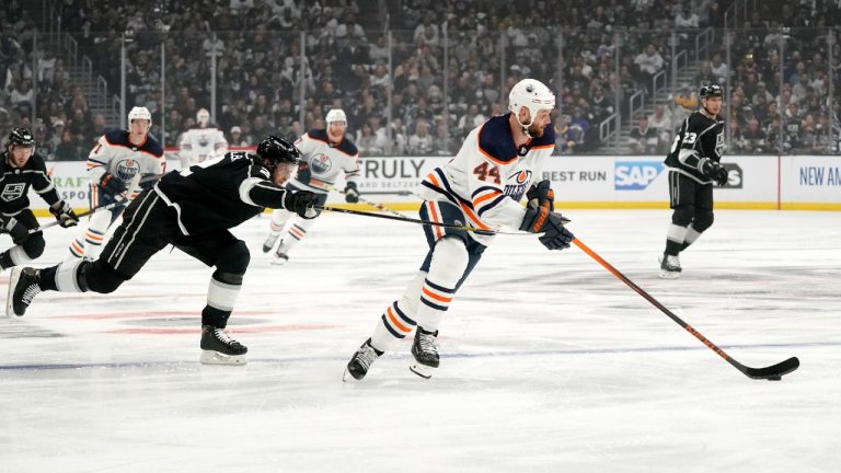 Edmonton Oilers right wing Zack Kassian (44) moss the puck as Los Angeles Kings defenseman Alexander Edler reaches in during the first period in Game 4 of an NHL hockey Stanley Cup first-round playoff series Sunday, May 8, 2022, in Los Angeles. (Mark J. Terrill/AP)