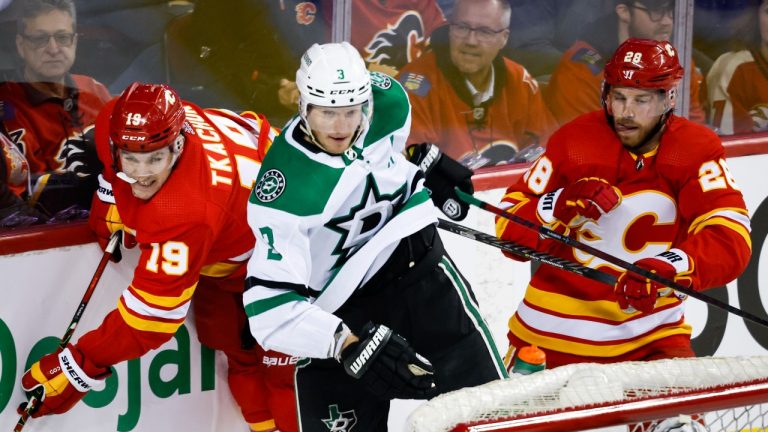 Dallas Stars defenceman John Klingberg (3) checks Calgary Flames left wing Matthew Tkachuk (19) as Flames centre Elias Lindholm (28) looks on during first period NHL playoff hockey action in Calgary, Tuesday, May 3, 2022. (Jeff McIntosh/THE CANADIAN PRESS)