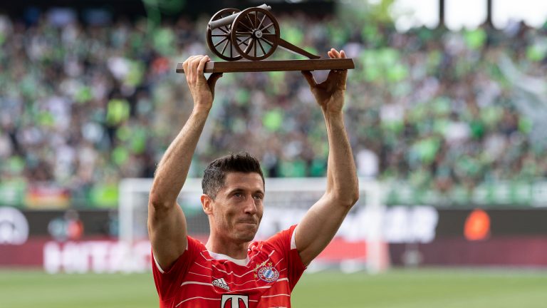 Bayern's Robert Lewandowski lifts the trophy after he was awarded as top scorer of the German Bundesliga after the soccer match between VfL Wolfsburg and Bayern Munich in Wolfsburg, Germany, Saturday, May 14, 2022. (Swen Pfoertner/dpa via AP)