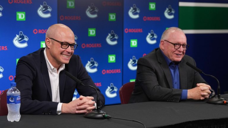 Vancouver Canucks general manager Patrik Allvin, left, and president of hockey operations Jim Rutherford laugh during an end of NHL hockey season news conference, in Vancouver, on Tuesday, May 3, 2022. (CP)