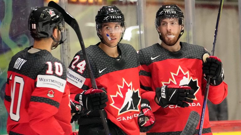 Dylan Cozens, centre, of Canada, celebrates his goal with teammates. (AP/CP)