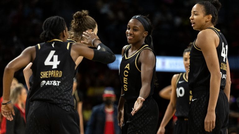 Las Vegas Aces guard Aisha Sheppard (4) slaps hands with guard Jackie Young, center, during the second half of a WNBA basketball game against the Phoenix Mercury Saturday, May 21, 2022, in Las Vegas. At right is Las Vegas Aces center Kiah Stokes (41). (Ellen Schmidt/AP)