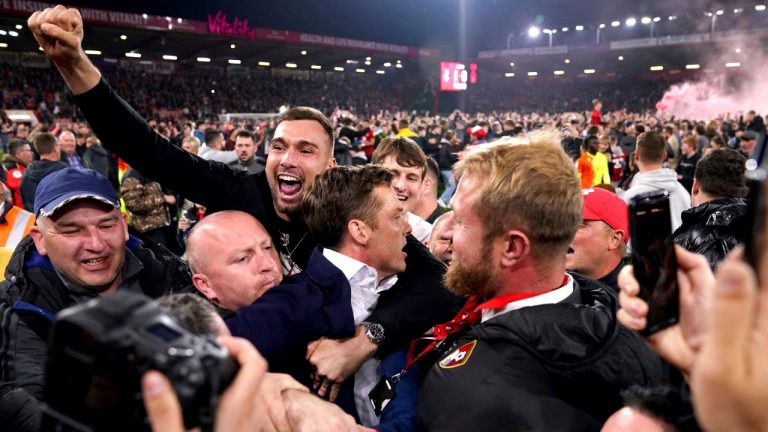 Bournemouth manager Scott Parker, centre, is surrounded as people celebrate winning promotion to the Premier League after defeating Nottingham Forest 1-0 at the Vitality Stadium in Bournemouth, England, on Tuesday, May 3, 2022. (John Walton/AP)