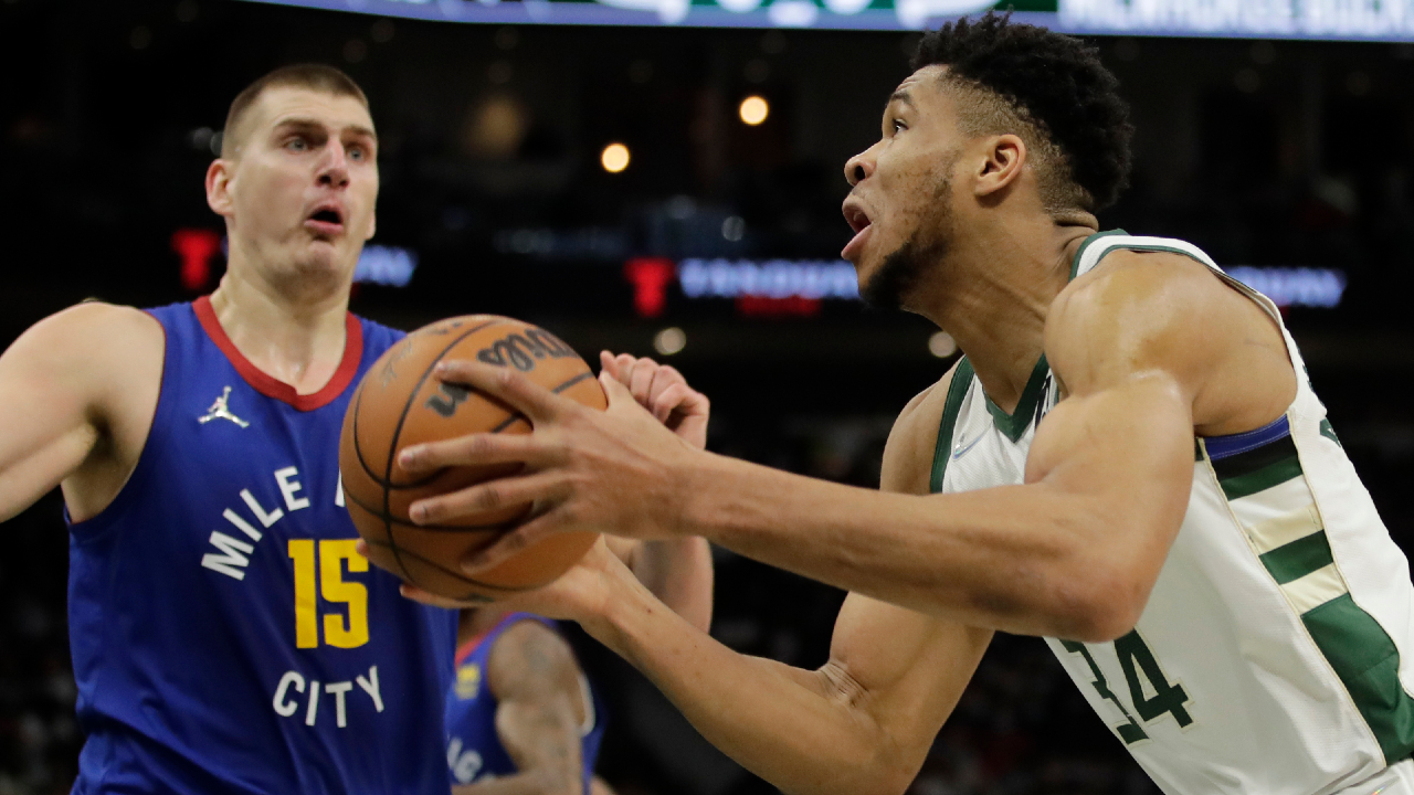 Milwaukee Bucks' Giannis Antetokounmpo, right, drives to the basket against Denver Nuggets' Nikola Jokic (15) during the second half of an NBA basketball game Sunday, Jan. 30, 2022, in Milwaukee. (Aaron Gash/AP) 