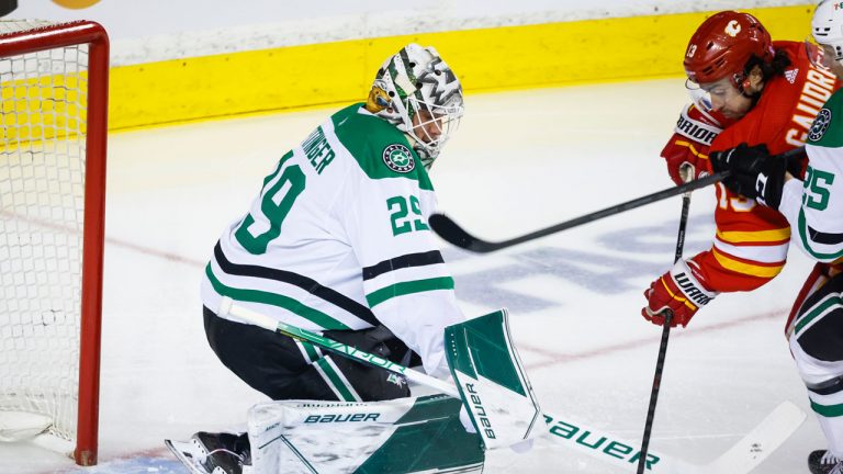 Dallas Stars goalie Jake Oettinger, left, blocks the net on Calgary Flames forward Johnny Gaudreau during first period NHL playoff hockey action. (Jeff McIntosh/CP)