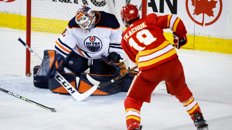 Edmonton Oilers goalie Mike Smith, left, lets in a goal from Calgary Flames' Matthew Tkachuk during second period NHL hockey action in Calgary, Saturday, March 26, 2022. (Jeff McIntosh/CP) 