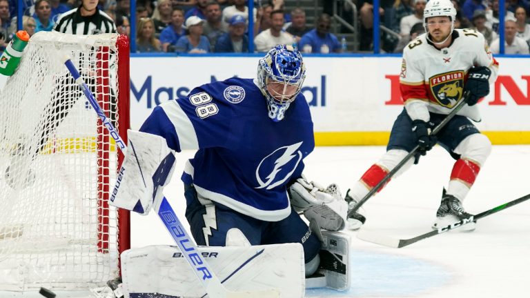 Tampa Bay Lightning goaltender Andrei Vasilevskiy (88) makes a save on a shot by Florida Panthers during the third period in Game 3 of an NHL hockey second-round playoff series Sunday, May 22, 2022, in Tampa, Fla. Panthers' Sam Reinhart (13) looks for a rebound. (Chris O'Meara/AP)