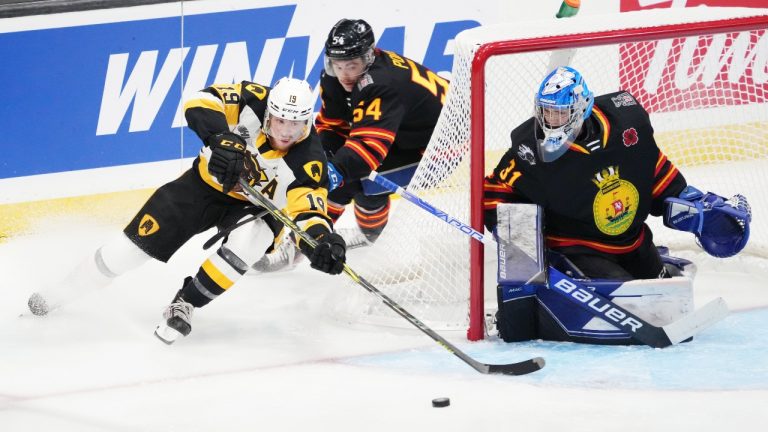 Hamilton Bulldogs' Jan Mysak, left, skates past Saint John Sea Dogs' Jeremy Poirier, centre, to try and score on goalie Nikolas Hurtubise during the first period of Memorial Cup hockey action in Saint John, N.B. on Monday, June 20, 2022. (Darren Calabrese/THE CANADIAN PRESS)