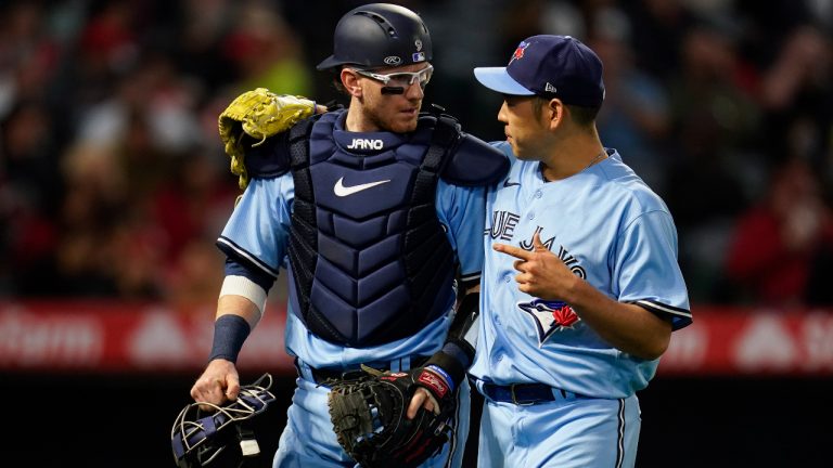 Toronto Blue Jays catcher Danny Jansen, left, talks with starting pitcher Yusei Kikuchi as they return to the dugout after the second inning of a baseball game against the Los Angeles Angels in Anaheim, Calif., Saturday, May 28, 2022. (AP Photo/Ashley Landis)