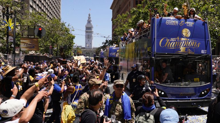 Stephen Curry and Damion Lee, right, ride atop a bus during the Golden State Warriors NBA championship parade in San Francisco, Monday, June 20, 2022. (Eric Risberg/AP)