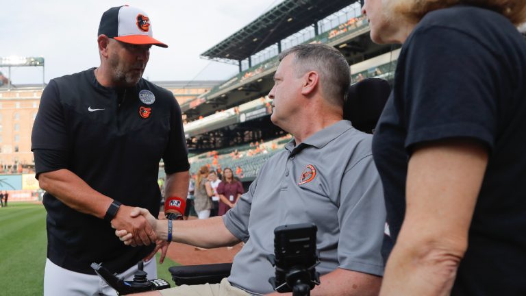 Baltimore Orioles manager Brandon Hyde, left, talks with former Orioles pitcher Jim Poole, center, and his wife, Kim Poole, prior to a baseball game against the Seattle Mariners, Thursday, June 2, 2022, in Baltimore. The Orioles honoured Lou Gehrig Day on Thursday. (Julio Cortez/AP)