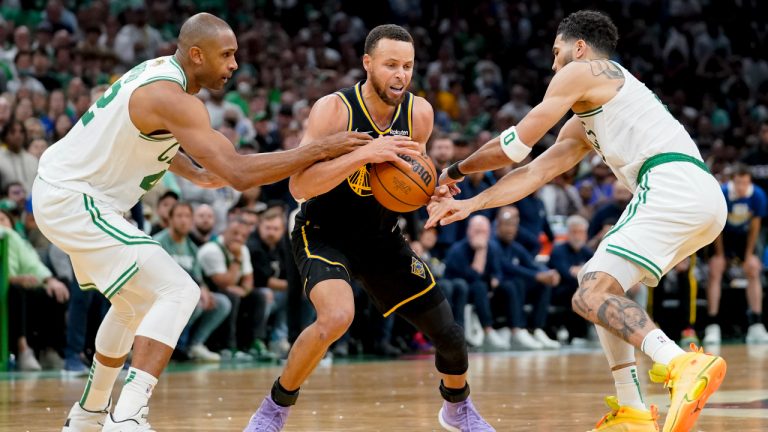 Golden State Warriors guard Stephen Curry (30) is double teamed by Boston Celtics center Al Horford (42) and forward Jayson Tatum (0) during the fourth quarter of Game 4 of basketball's NBA Finals, Friday, June 10, 2022, in Boston. (Steven Senne/AP)