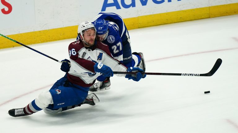 Colorado Avalanche right wing Mikko Rantanen (96) reaches for the puck as Tampa Bay Lightning defenseman Ryan McDonagh (27) defends during the third period of Game 4 of the NHL hockey Stanley Cup Finals on Wednesday, June 22, 2022, in Tampa, Fla. (John Bazemore/AP)