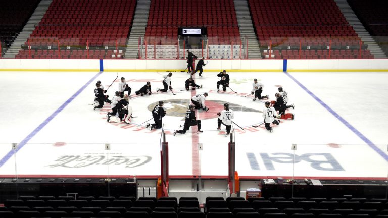 Ottawa Senators players stretch at centre ice at the Canadian Tire Centre during the team's training camp in Ottawa, on Thursday, Sept. 23, 2021. (Justin Tang/CP)