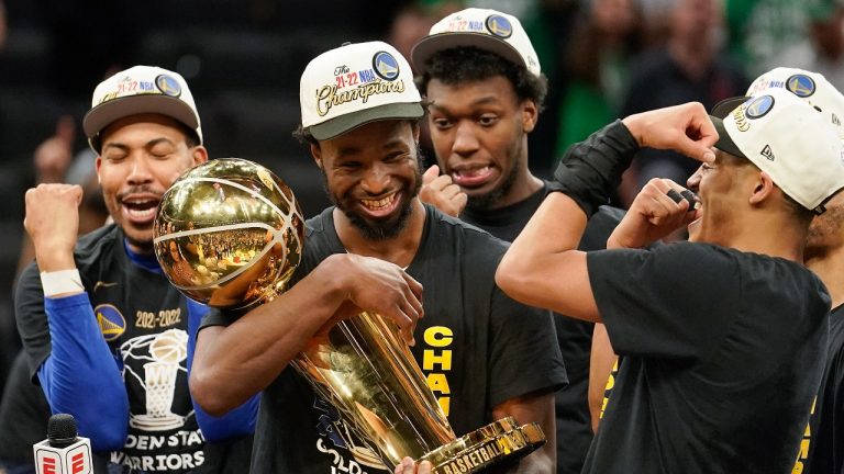 Andrew Wiggins of the Golden State Warriors celebrates with the Larry O'Brien Trophy after beating the Boston Celtics in Game 6 of basketball's NBA Finals, Thursday, June 16, 2022, in Boston. (Steven Senne/AP)