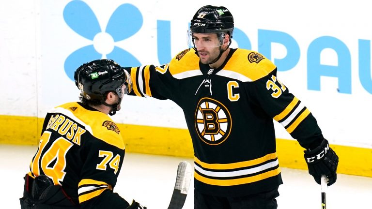 Boston Bruins center Patrice Bergeron (37) is congratulated by Jake DeBrusk (74) after his goal against the Buffalo Sabres during the second period of an NHL hockey game, Thursday, April 28, 2022, in Boston. (Charles Krupa/AP)